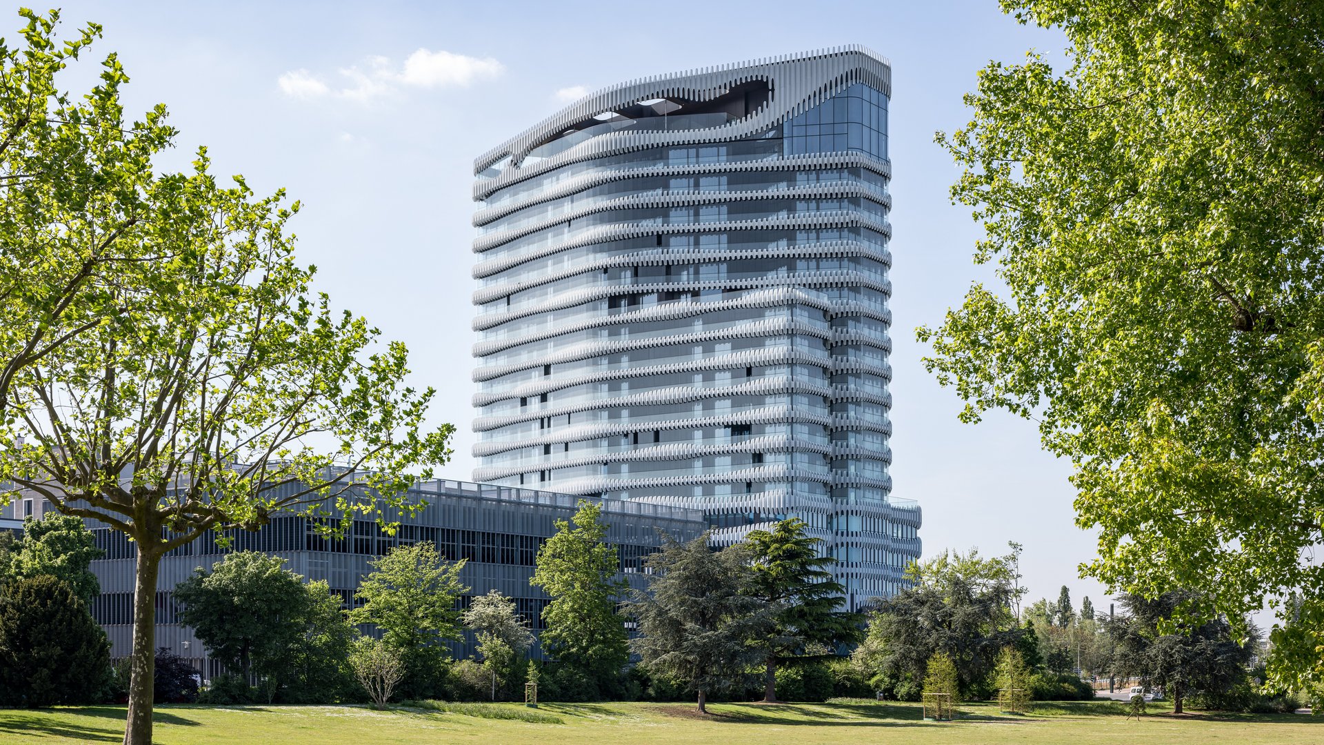 The Zipper building in the green, trees, grass, park